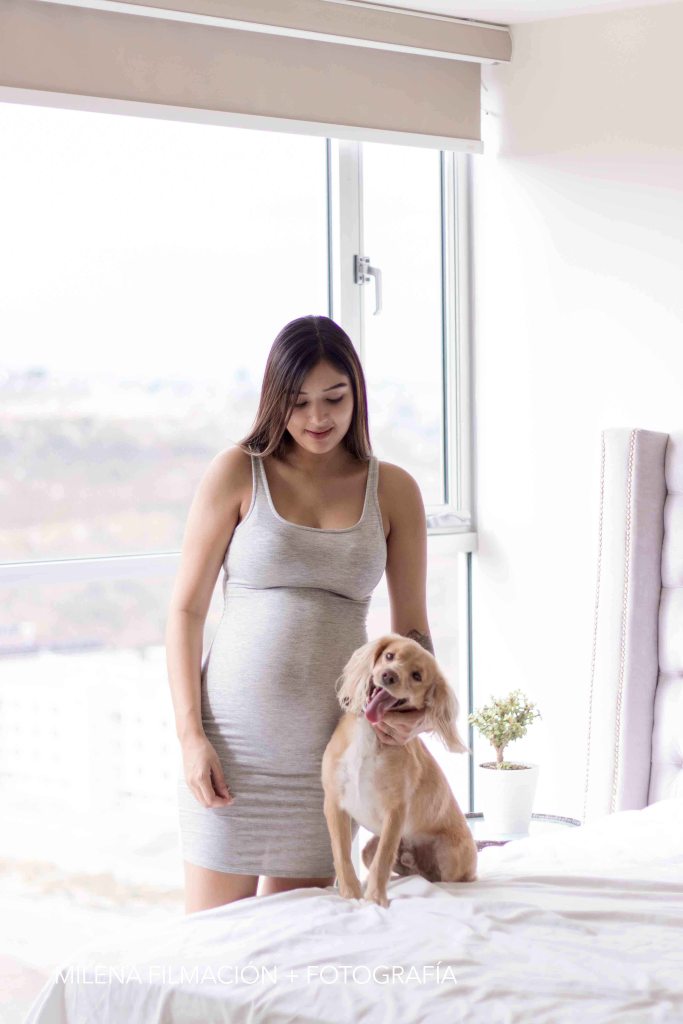 Sesión de fotos de embarazo en casa con mascota en cama