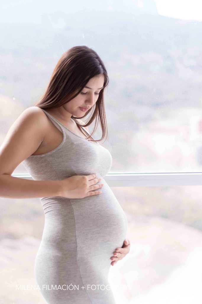 Sesión de fotos de embarazo en una ventana