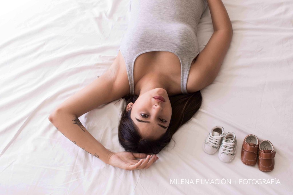 Mamá con zapatos de bebé - sesión embarazo con luz natural