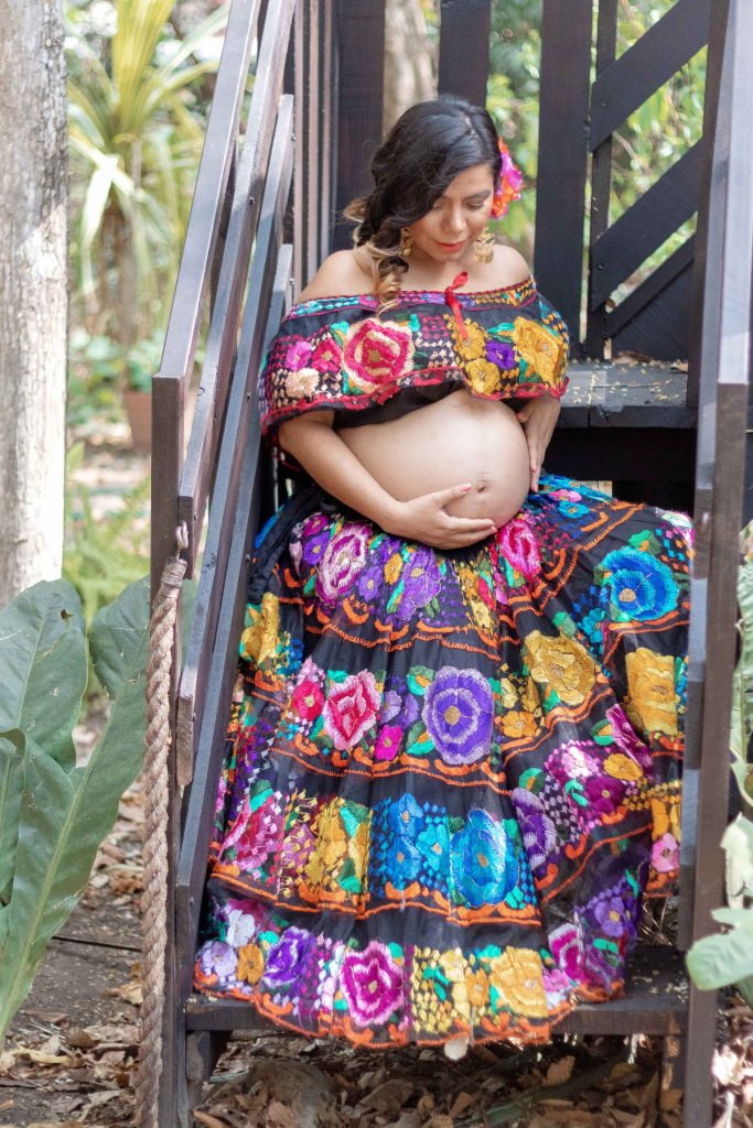 Mamá vestida de chiapaneca sentada en escaleras