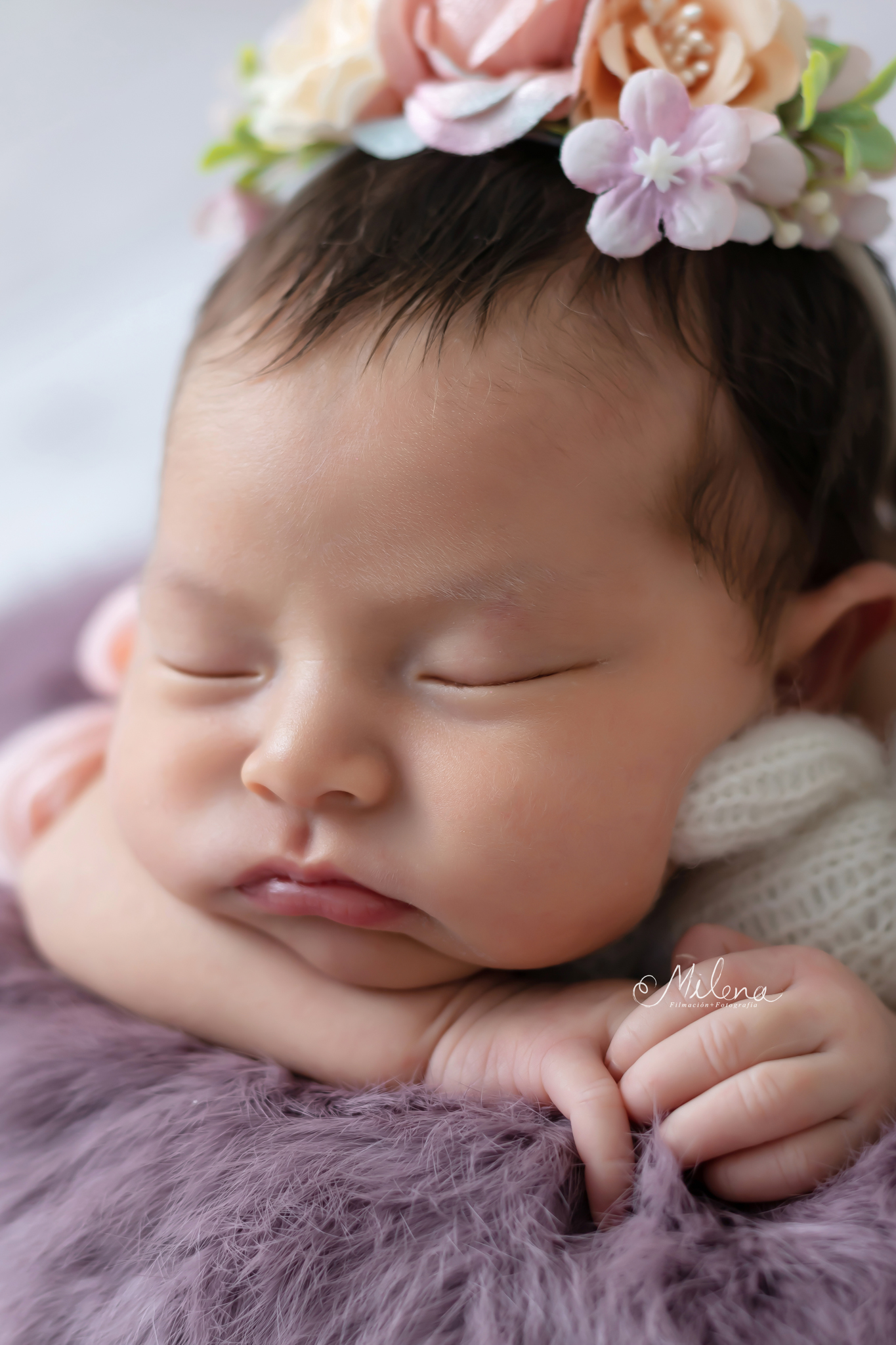 sesión newborn segura para niña en una cubeta con flores y orejas de conejo